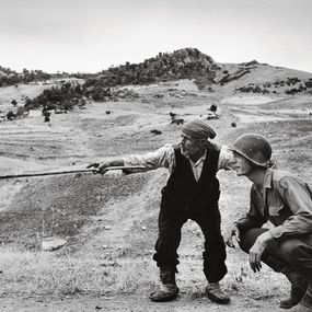 [object Object] - A Sicilian peasant shows an American officer the path taken by the Germans