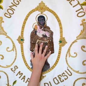 [object Object] - A child touches the banner of the brotherhood of San Benedetto il Moro