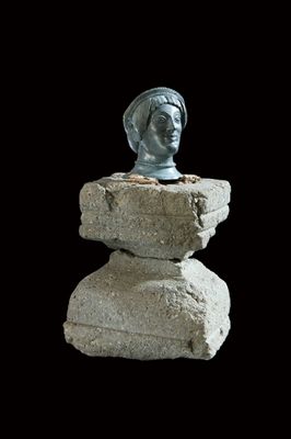 Female bronze head on a stone base
