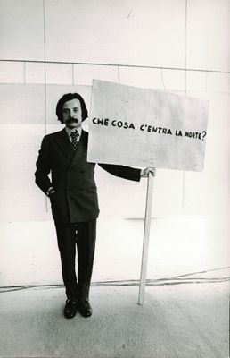Achille Bonito Oliva con il cartello di Gino De Dominicis