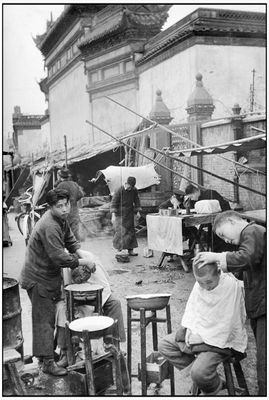 Henri Cartier-Bresson - En période de panique et d'évasions, shampoing et coupe de cheveux dans la rue.