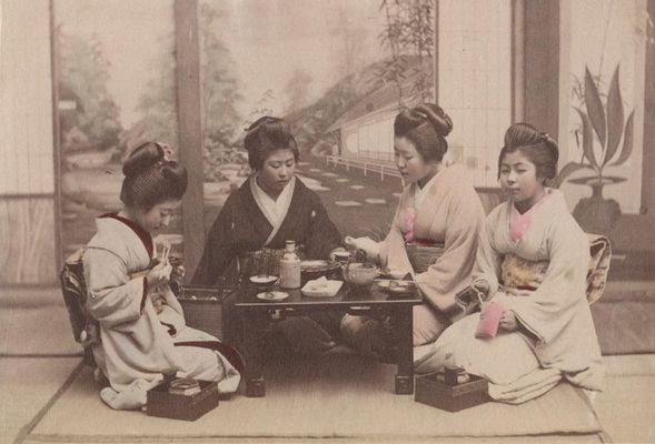 Gruppo di donne giapponesi in kimono attorno a un tavolo da té imbandito