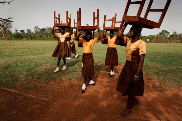Randy Olson - Ghanaian students bring chairs for the inauguration ceremony of the Maranatha Maternity Clinic